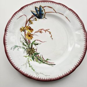 Assiette à dîner en faïence de Sarreguemines, modèle Papillon,à décor de fleur bleue.